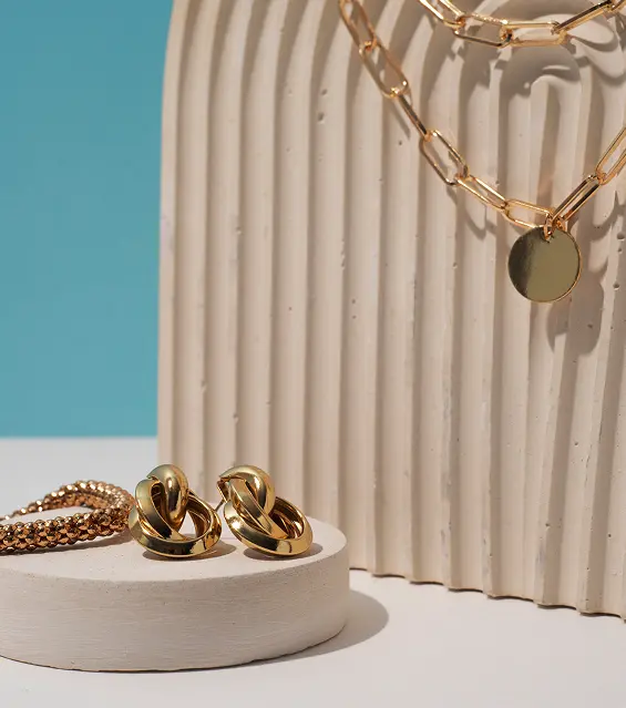 Gold jewelry collection featuring hoop earrings and a chain necklace